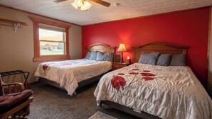 A bedroom with two beds, a ceiling fan, a window, and a red wall. - KJ's Inn and Suites By OYO Gettysburg U.S. Hwy 212 (Gettysburg)