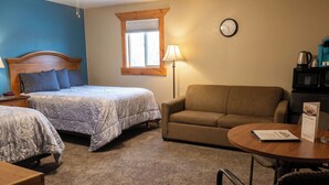 A bedroom with two beds, a sofa, a lamp, a clock, and a coffee maker. - KJ's Inn and Suites By OYO Gettysburg U.S. Hwy 212 (Gettysburg)