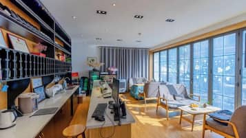Un espacio de oficina moderno con un escritorio grande, computadora y zona de estar.