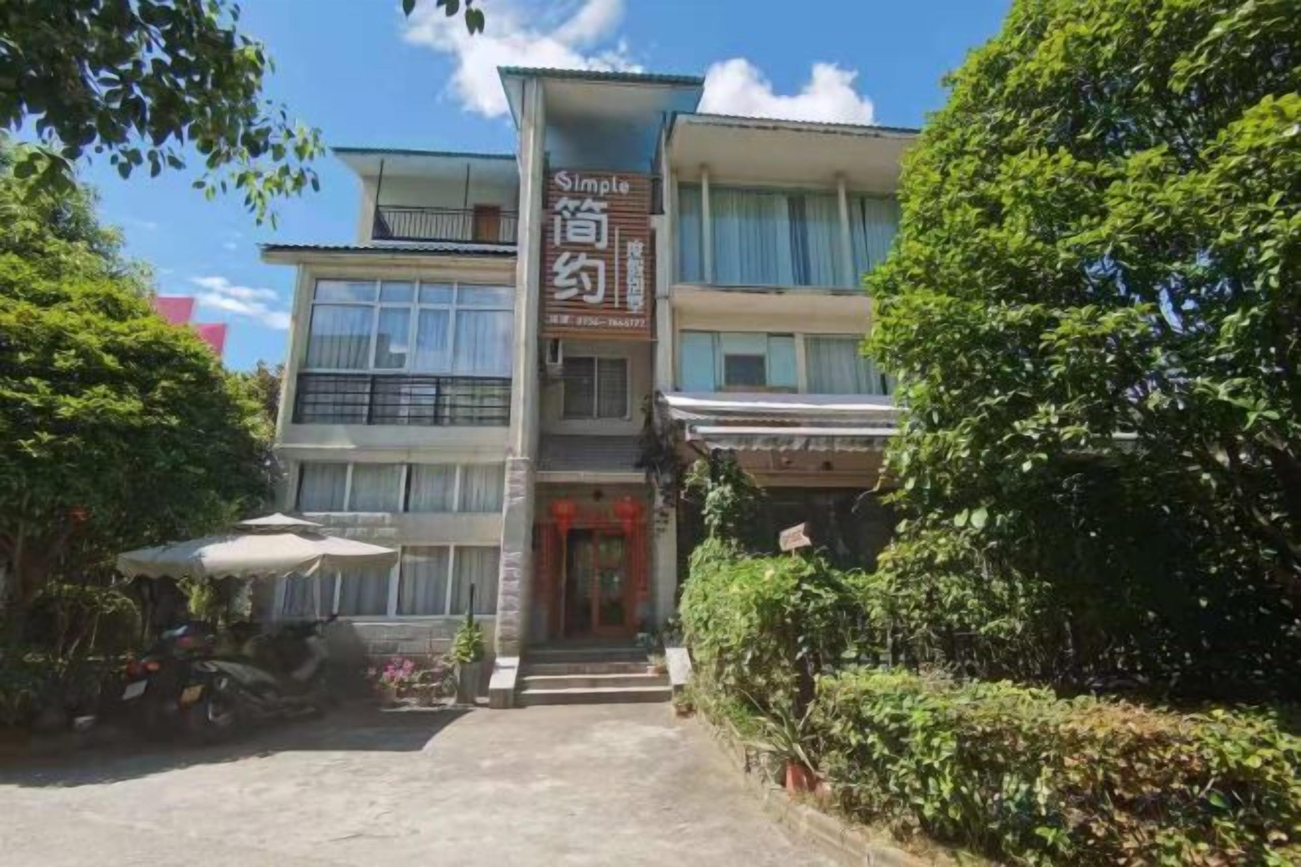 Un edificio de dos pisos con un letrero que dice 'Simple' y 'Boutique Hotel'.