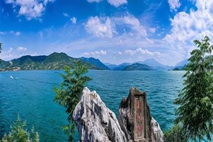 A lake with mountains in the background and a wooden structure in the foreground.