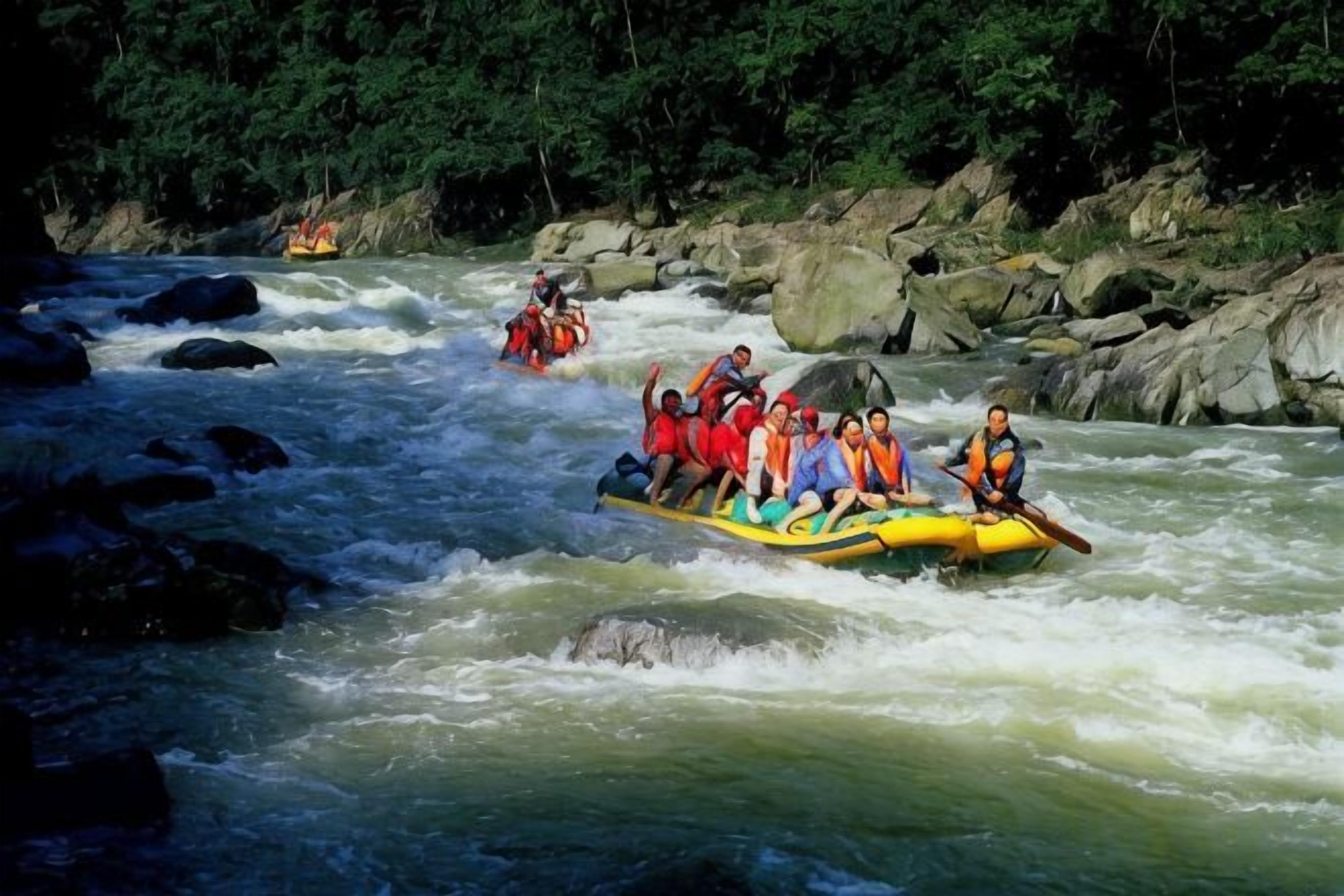 A group of people rafting down a river surrounded by rocks and trees.