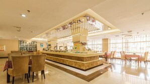 A hotel lobby with a central reception desk, seating area, and large windows allowing natural light. - Royal Hotel (Tuquan)