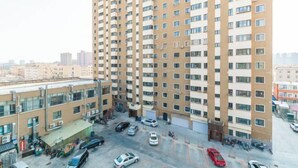 A high-rise residential building with multiple balconies and a parking area in front. - Royal Hotel (Tuquan)