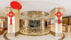 A hotel lobby with a circular marble floor, a central chandelier, and red lanterns. - Royal Hotel (Tuquan)