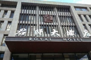 Un hotel con una fachada moderna, que presenta un cartel llamativo con el nombre 'ROYAL HOTEL' en inglés y caracteres chinos.