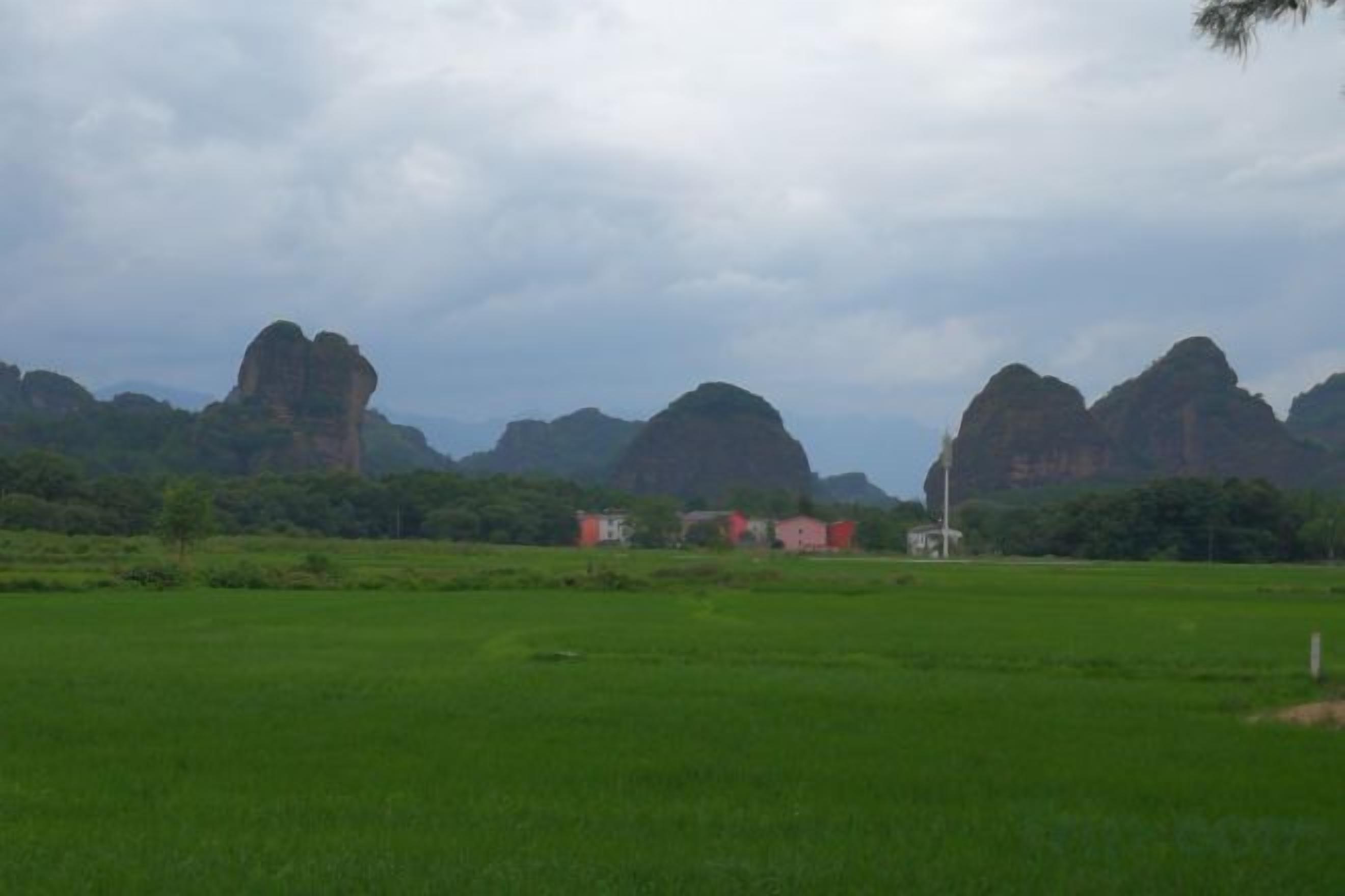 Eine Landschaft mit grünen Feldern und weit entfernten Felsformationen.