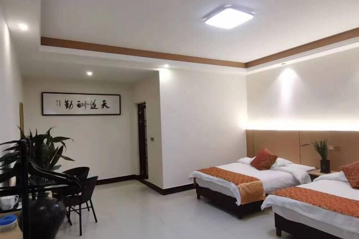 Een hotelkamer met twee bedden, een bureau en een stoel.