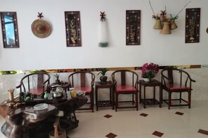 A dining area with a table set for four, surrounded by four chairs, and a wall with framed decorations. - Longhushan Fengshanxige Homestay (Guixi)