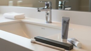 A modern bathroom with a white sink, a mirror, and a toothbrush holder. - Modern Studio Apt in Charming Nakamachi Area (Hiroshima)