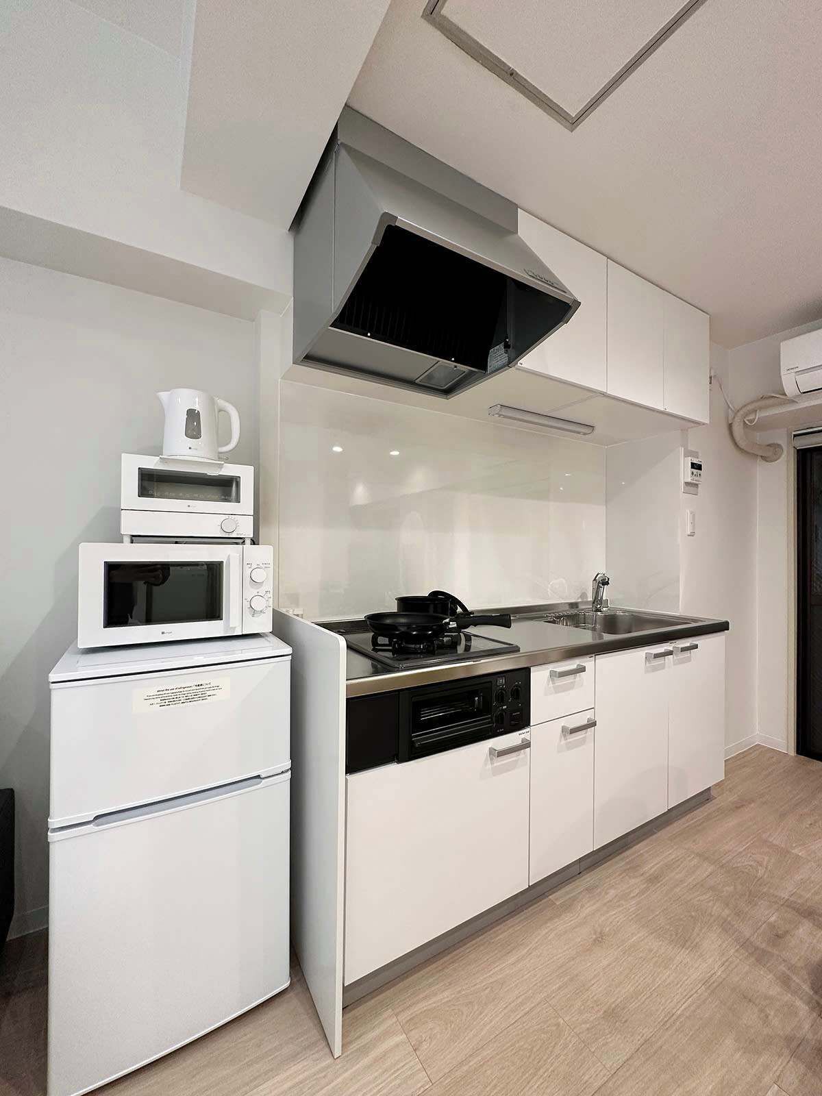 Kylskåp, mikrovågsugn, spishäll och grytor/köksredskap