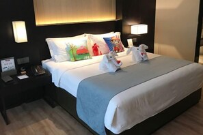A hotel room with a bed, two bedside lamps, a nightstand with a phone, and decorative pillows. - Yue Hotel (Fuzhou)