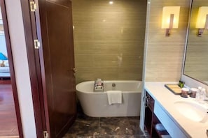 Une salle de bain avec une baignoire sur pieds, un lavabo et un miroir.