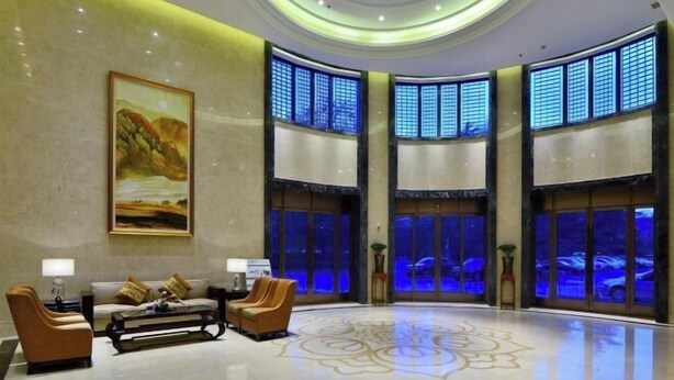 A lobby with a large painting, seating area, and large windows with blue lighting. - Ningwozhuang Hotel (Building 1) (Lanzhou)