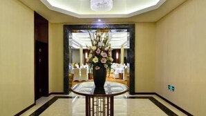 A hotel lobby with a round table, a chandelier, and a floral arrangement. - Ningwozhuang Hotel (Building 1) (Lanzhou)