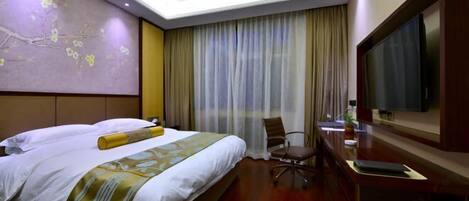 Habitación de hotel con una cama grande, un escritorio con televisor de pantalla plana y un ventanal con cortinas.