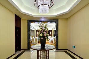 A hotel lobby with a round table, a large vase of flowers, and a chandelier. - Ningwozhuang Hotel (Building 1) (Lanzhou)