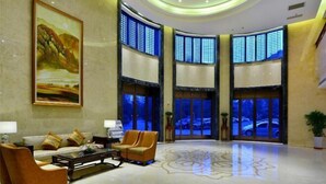 A spacious lobby with a large painting, seating area, and large windows with blue-tinted glass. - Ningwozhuang Hotel (Building 1) (Lanzhou)