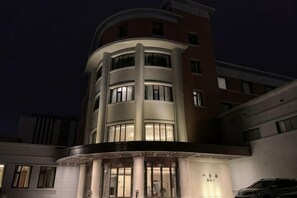 A multi-story hotel with a curved facade, illuminated windows, and a visible entrance. - Ningwozhuang Hotel (Building 1) (Lanzhou)