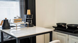 A modern kitchen with a coffee maker, a kettle, and a frying pan on the counter. - Luxurious Loft Suite at Mansfield, Central NYC Location near Top Attraction (New York)