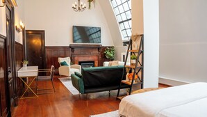 A loft-style bedroom with a large bed, a sofa, a fireplace, and a TV. - Luxurious Loft Suite at Mansfield, Central NYC Location near Top Attraction (New York)