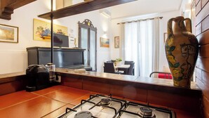 A kitchen with a gas stove, a coffee machine, and a large vase on the counter. - Le dimore del mito - Atalanta (Syracuse)