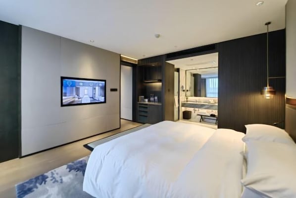 A modern hotel room with a large bed, a flat-screen TV mounted on the wall, a walk-in closet, and a bathroom with a large mirror. - Simen Hotel (Ningbo)
