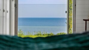 A view from an open window overlooking a calm sea with a clear horizon. - 3 bedroom beautiful home in Holbæk (Holbæk)