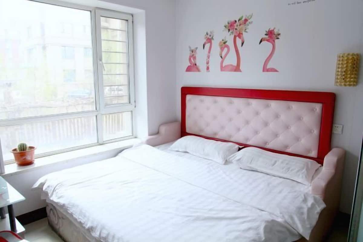 Un dormitorio con cama, ventana y decoración en la pared.