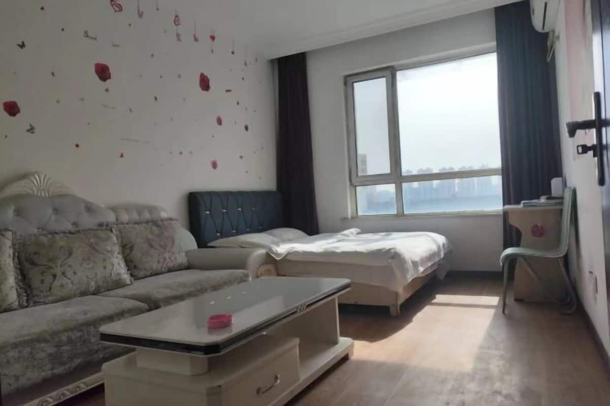 Una habitación con sofá, cama, escritorio y silla.