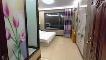 Una habitación de hotel con cama, ventana, cortina y puerta.