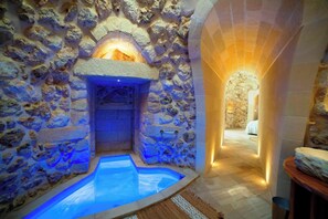 A stone-walled spa area with a hot tub and a wooden bench. - Trullo Meraviglia With Garden And Pool (Castrignano de' Greci)