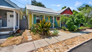 A row of colorful houses with a paved walkway and a small garden area. - Casa Amarillo l Steps to Historic District (St. Augustine)