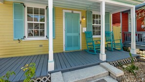 A porch with teal shutters, a door marked '72', and two rocking chairs. - Casa Amarillo l Steps to Historic District (St. Augustine)