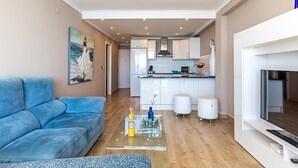 A modern living room with a blue sofa, a glass coffee table, and a fireplace. - Altea Bahia - Altea, Costa Blanca (Altea)
