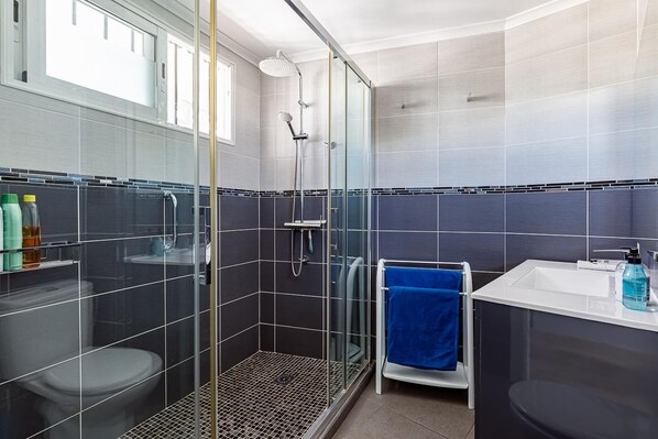 A modern bathroom with a glass-enclosed shower, a white sink, and a blue towel. - Altea Bahia - Altea, Costa Blanca (Altea)