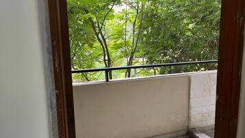 Un balcon donnant sur un paysage verdoyant et luxuriant.