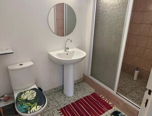Een douche, handdoeken, shampoo, toiletpapier