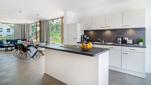 A modern kitchen with white cabinets, a dark countertop, and a fruit bowl. - Holiday Home 'Architektenhaus C1 Mit Seesicht' with Lake View, Private Terrace and Wi-Fi (Öhningen)