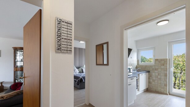 Ein modernes Interieur mit einem Flur, der zum Schlafzimmer und zur Küche führt.