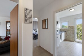 Un interior moderno con un pasillo que conduce a un dormitorio y una cocina.
