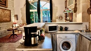 A compact kitchen with a washing machine, a microwave, and a coffee maker. - Mas Provençal à 10 Minutes de Nîmes. Animaux de Compagnie Acceptés ! (Générac)