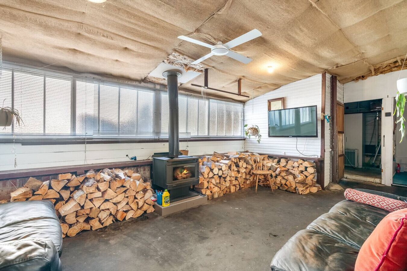 Ein gemütliches Wohnzimmer mit Kamin, einem an der Wand montierten Fernseher und einer komfortablen Sitzecke.
