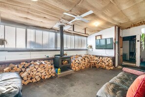 A cozy living room with a fireplace, a TV mounted on the wall, and a comfortable seating area. - Cosy Upgraded Character Home in Leafy West Hobart (West Hobart)