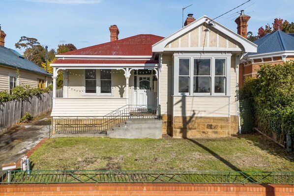 Traditional two-story house with a central entrance and small porch area.