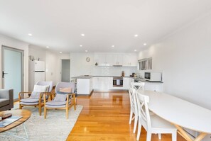 A modern apartment with a kitchen, dining area, and living room. - Sunny Retreat in Kingston Beach (Kingston Beach)