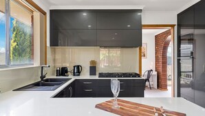 Una cucina moderna con un'isola grande, mobili neri e vista sull'esterno.
