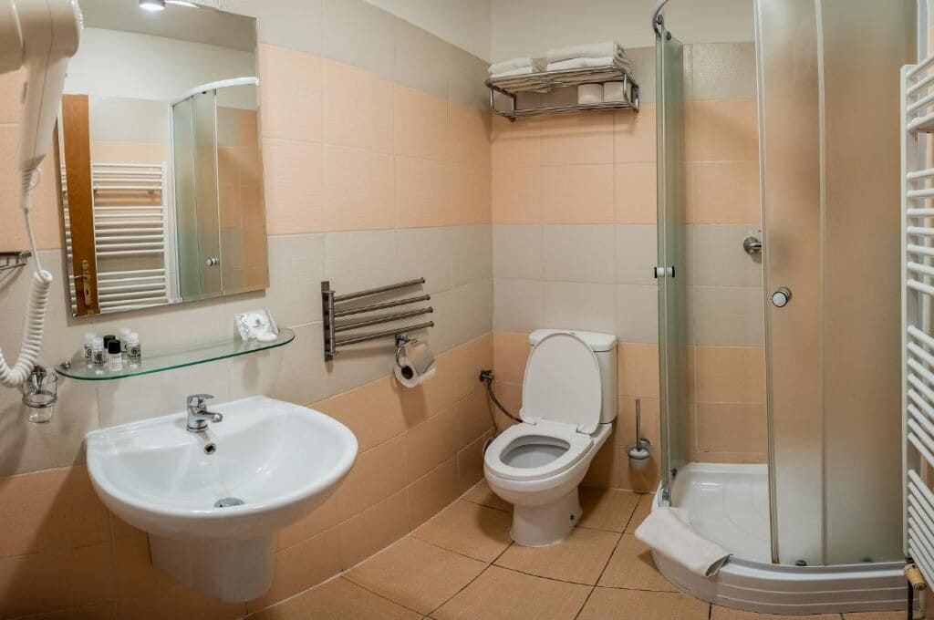 A bathroom with a sink, toilet, and glass-enclosed shower.