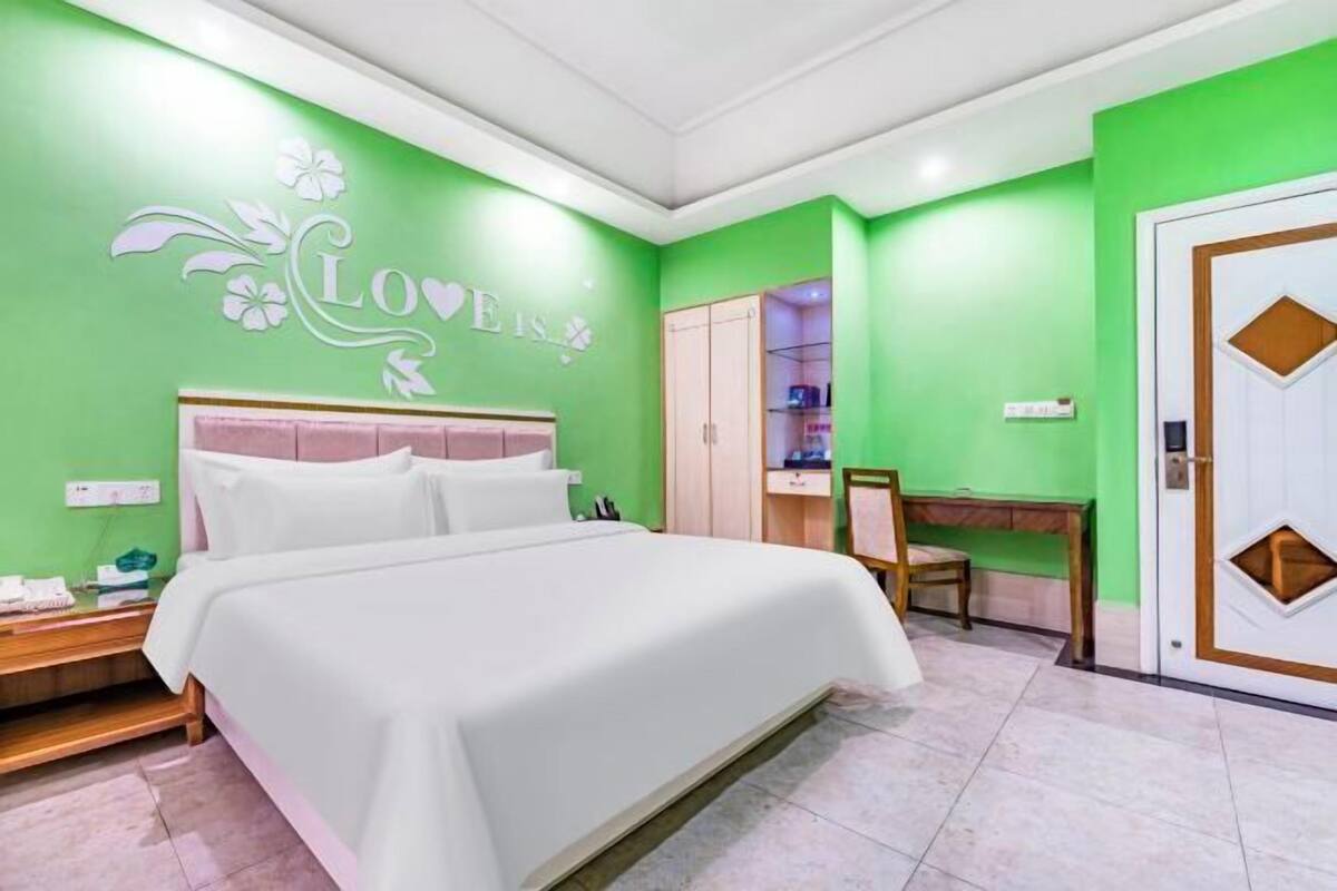 A hotel room with a bed, a desk, and a wardrobe.