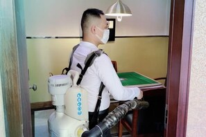 A person in a room with a table, a chair, and a lamp. - Yuheng Hotel Foshan (Foshan)